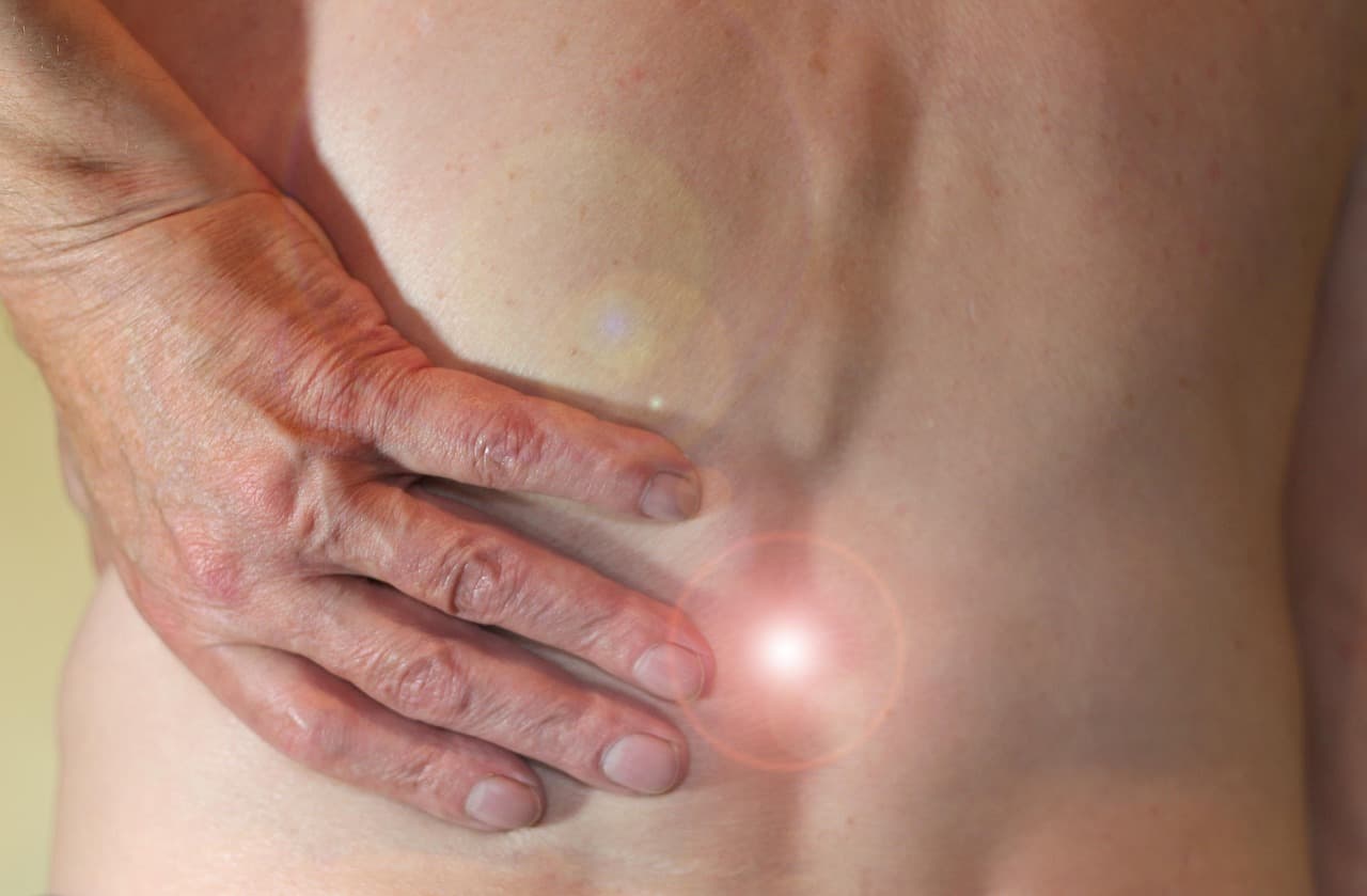 Hand on the lower back where it hurts
